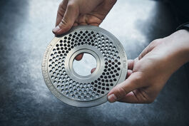 Anlagen- und Maschinenbau: Auszubildende hält Werkstück einer Matritze 