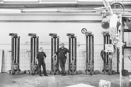 Dokumentation Busbetriebshof: Mitarbeiter vor mobilen Hebeböcken 