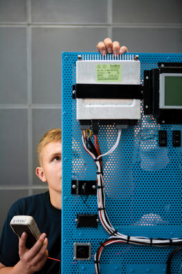 Fahrzeugtechnik: Auszubildende hinter Schalttafel 