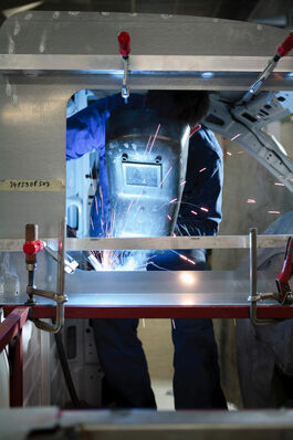 Fahrzeugtechnik: Kfz-Mechatroniker beim Schweissen eines Chassis 