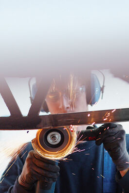 Fahrzeugtechnik: Kfz-Mechatroniker beim Trennschleifen am Bus 