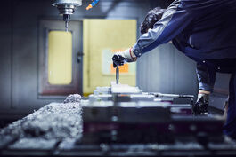 Metallverarbeitung: Einspannen eines Werkstücks zum Fräsen in CNC-Maschine 