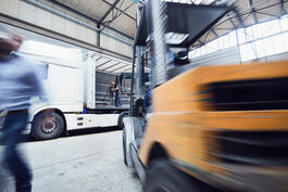 Metallverarbeitung: Gabelstapler in Werkhalle entlädt LKW-Anhänger 