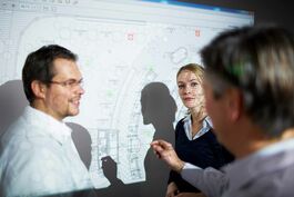 Schifffahrt: Team im Planungsgespräch vor Beamer 