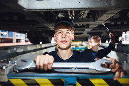 Fahrzeugtechnik: Auszubildende Kfz-Mechatroniker in Werkstattgrube 