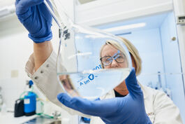 Lebensmittelwirtschaft: Laborantin mit Probe im Messkolben 